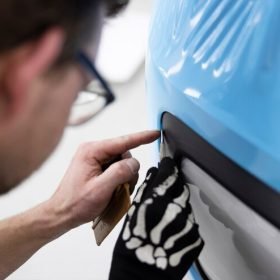 close-up-professional-wrapping-car-with-blue-cover_23-2149385688